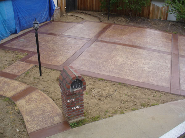 A red brick concrete parking pad in front of garage.